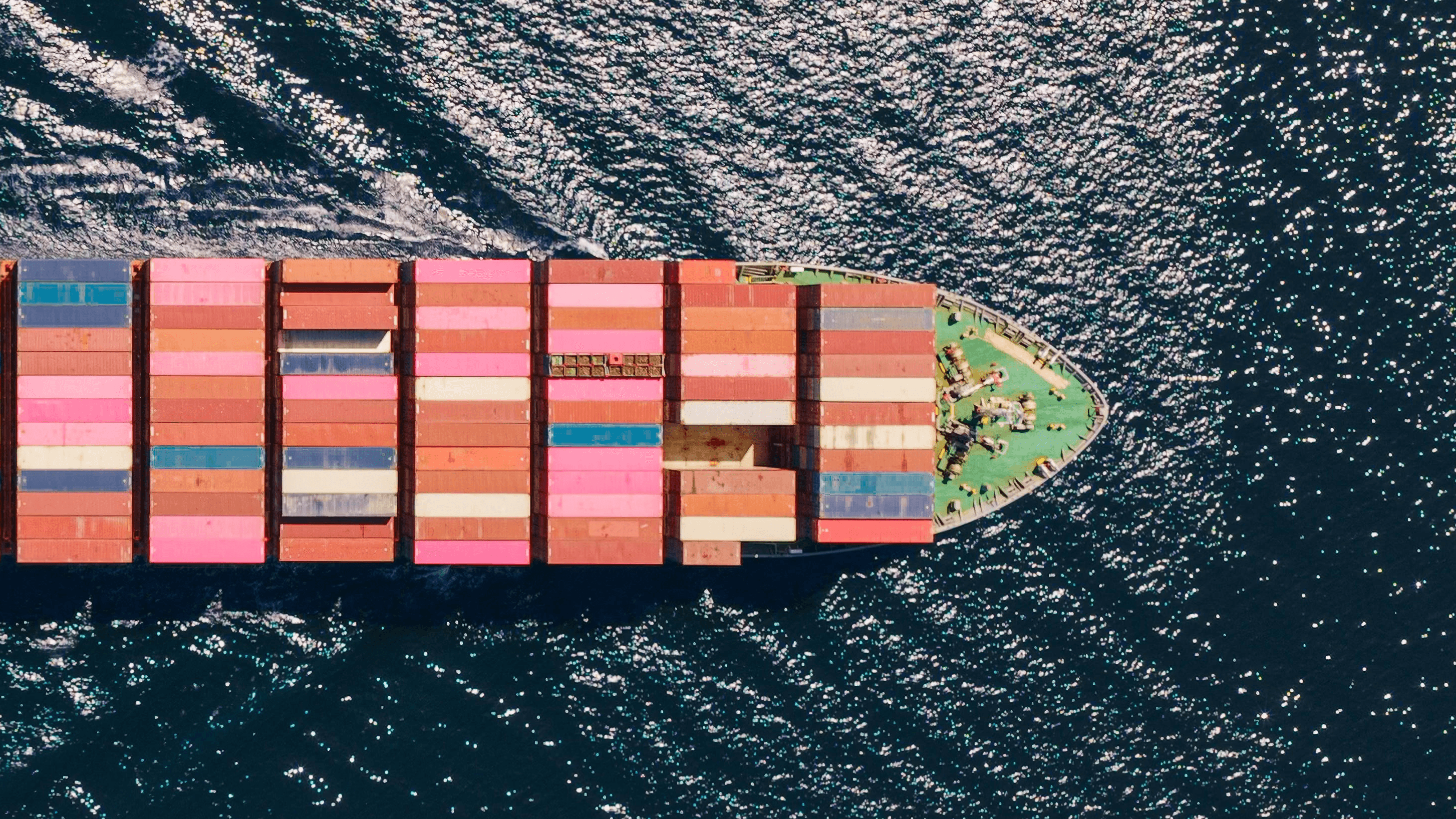 Vue aérienne d’un porte-conteneurs transportant des conteneurs colorés en mer.