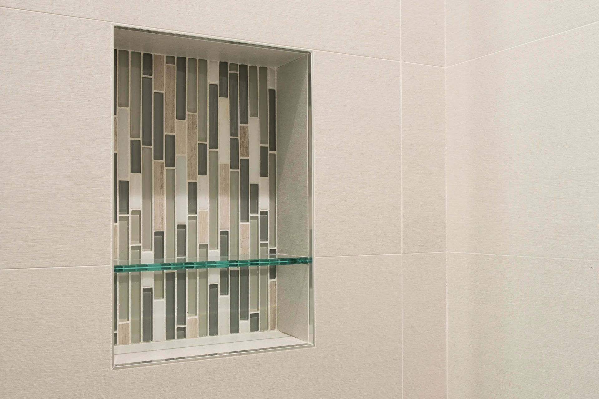Close-up of the guest bathroom's shower niche, showcasing the contemporary design and quality materials in the Harbor Cove remodel.