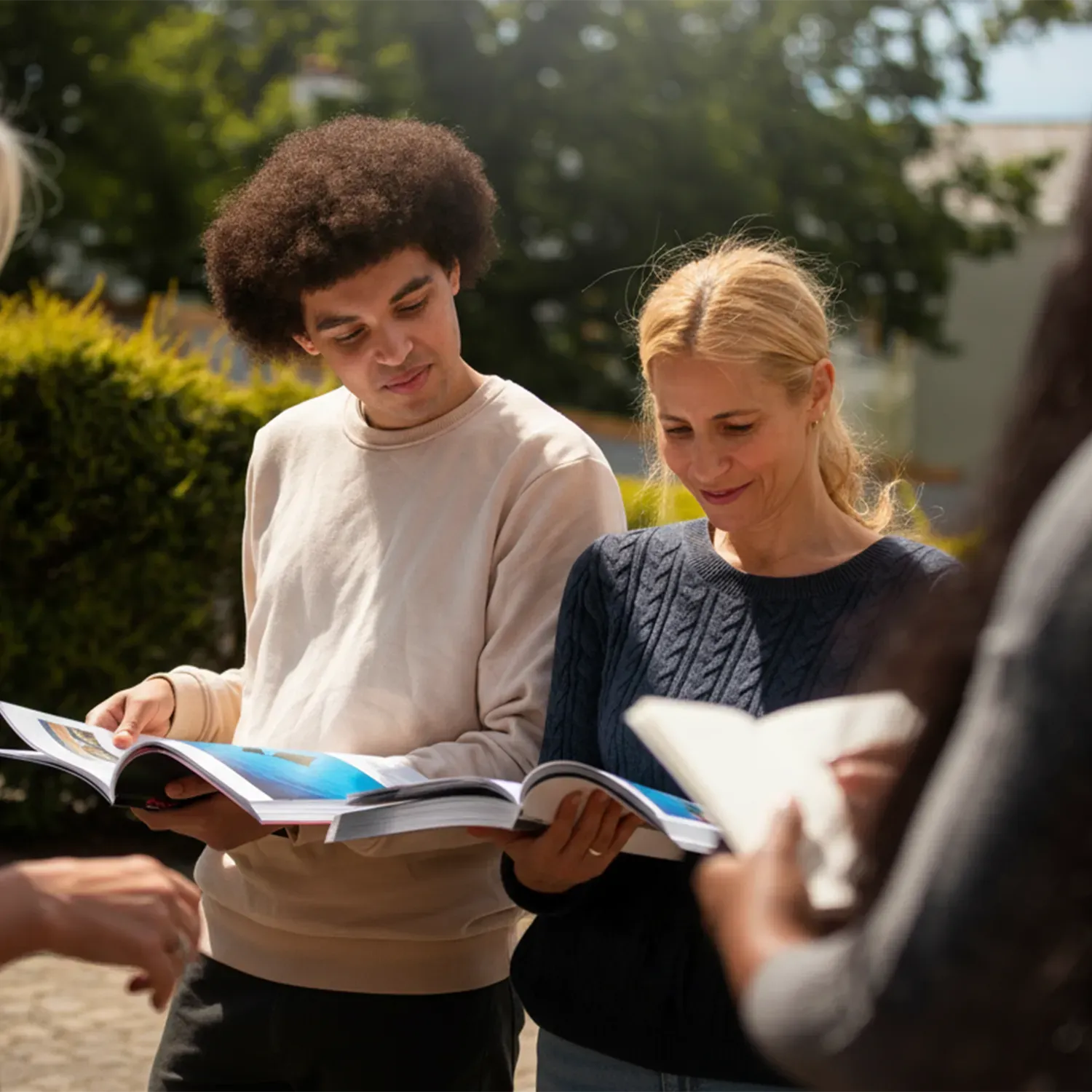 Dvojice nahlíží do otevřené knihy. Symbol sdílení vize, respektu a partnerského přístupu.