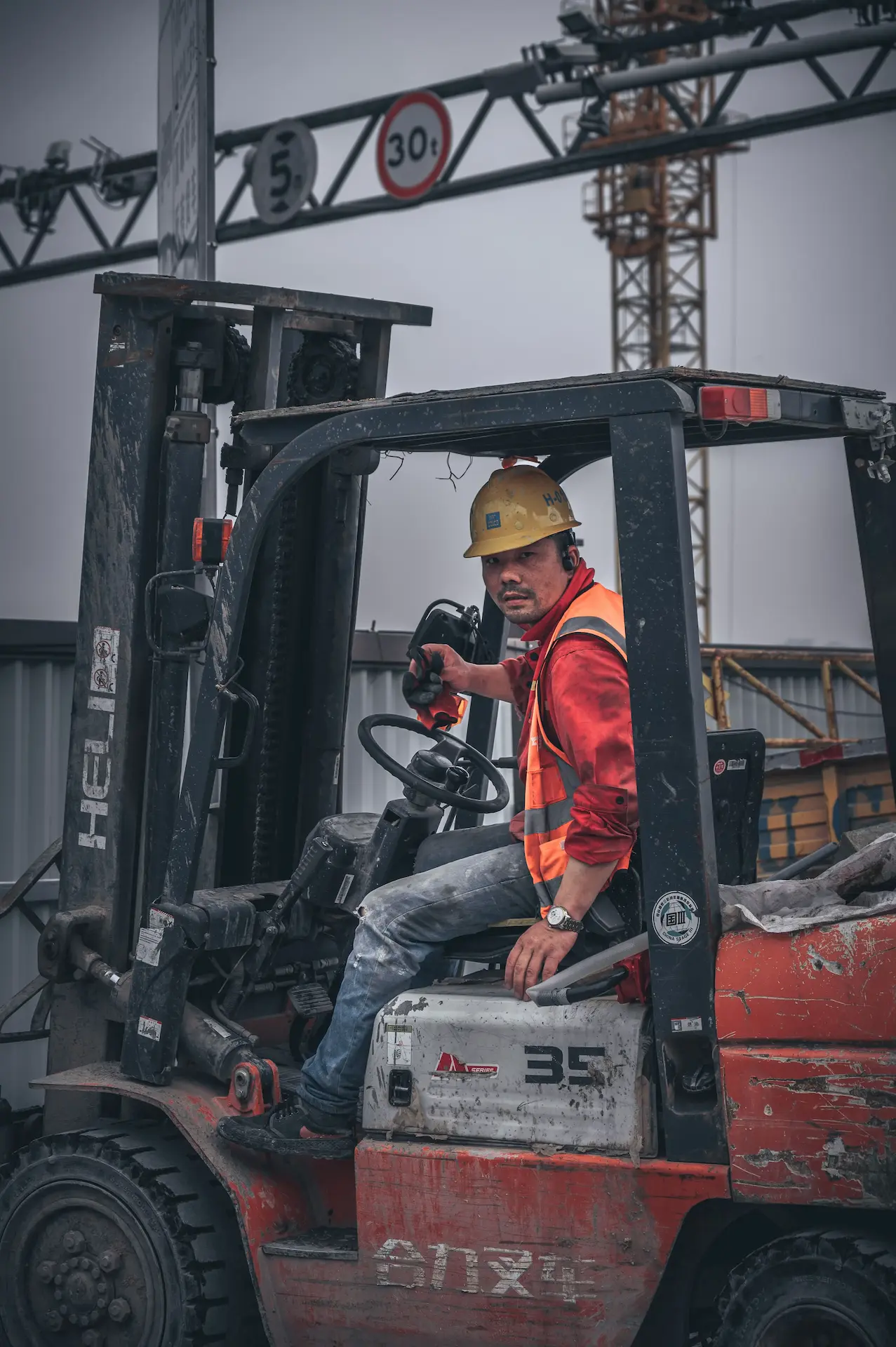 Warehouse worker operating an electric pallet jack beside stacked boxes