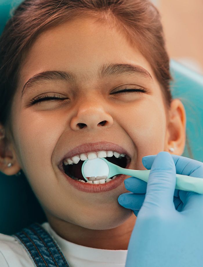 Happy child getting dental exam in Arlington