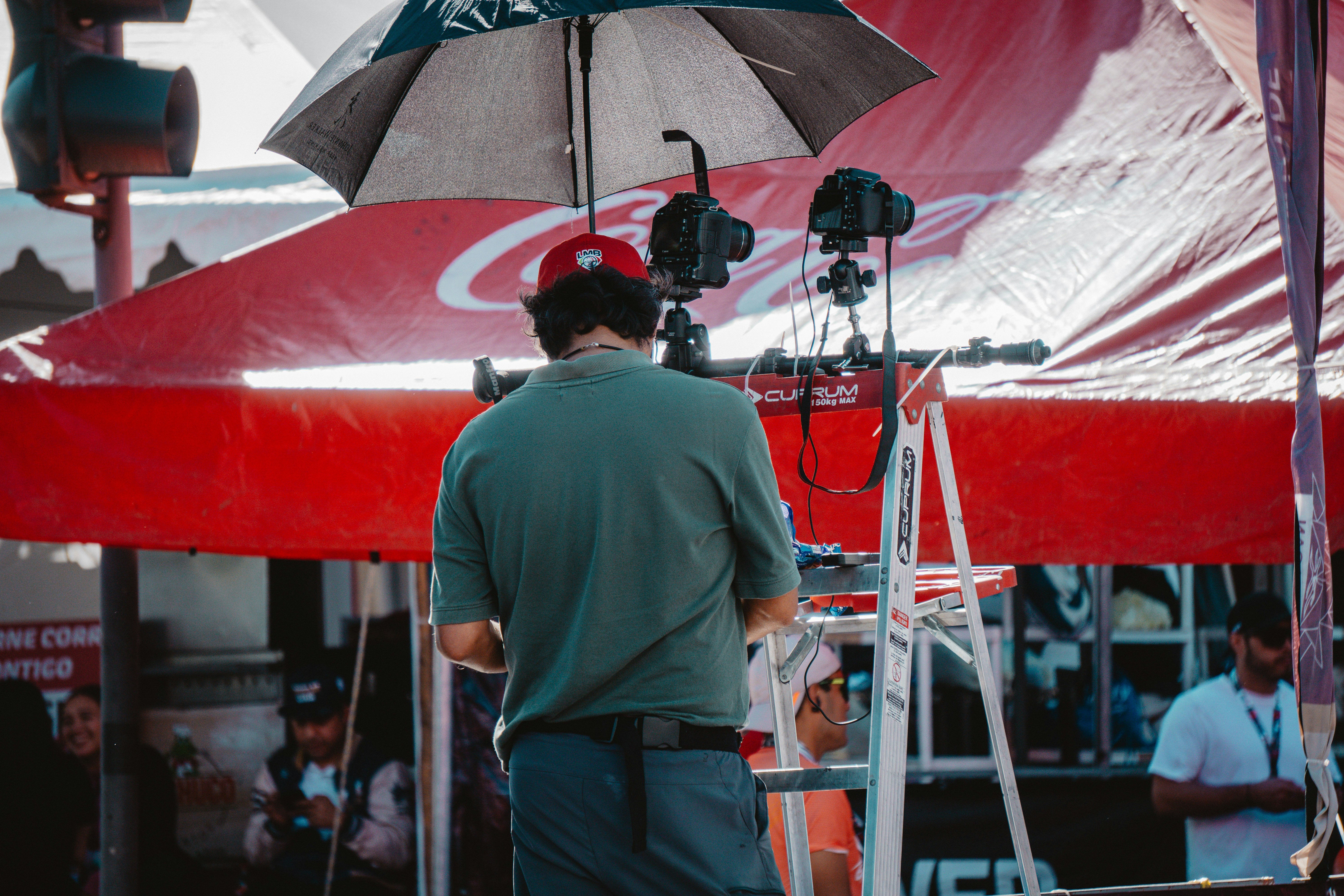 Man filming with cameras under umbrella and tent