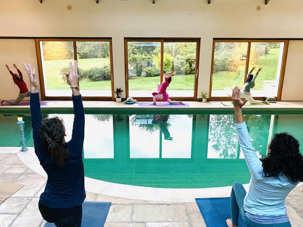 Personnes pratiquant le yoga autour d'une piscine.