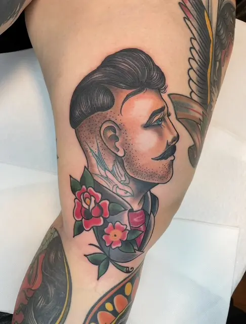 Traditional-tatuering med mansporträtt och rosor på lår, High Heels Tattoo Västervik