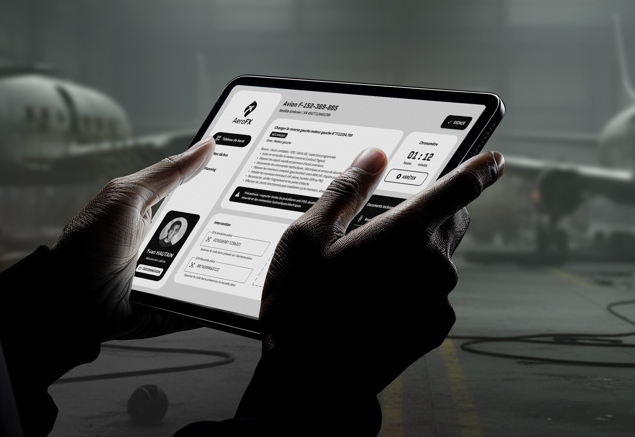 Technicien tenant tablette avec application métier dans atelier aéronautique