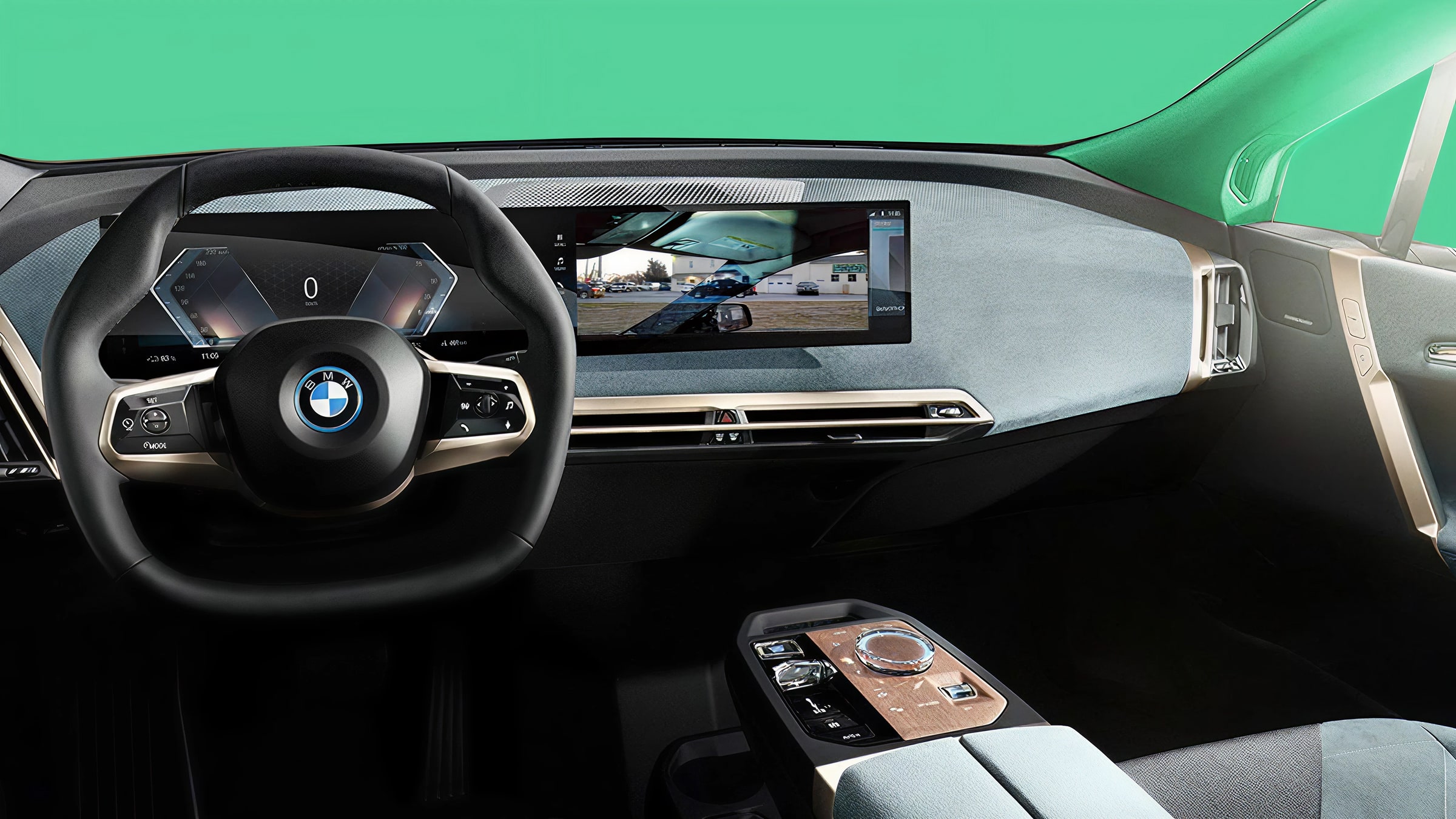 BMW iX interior with centre display showing a street scene, green background visible through windscreen