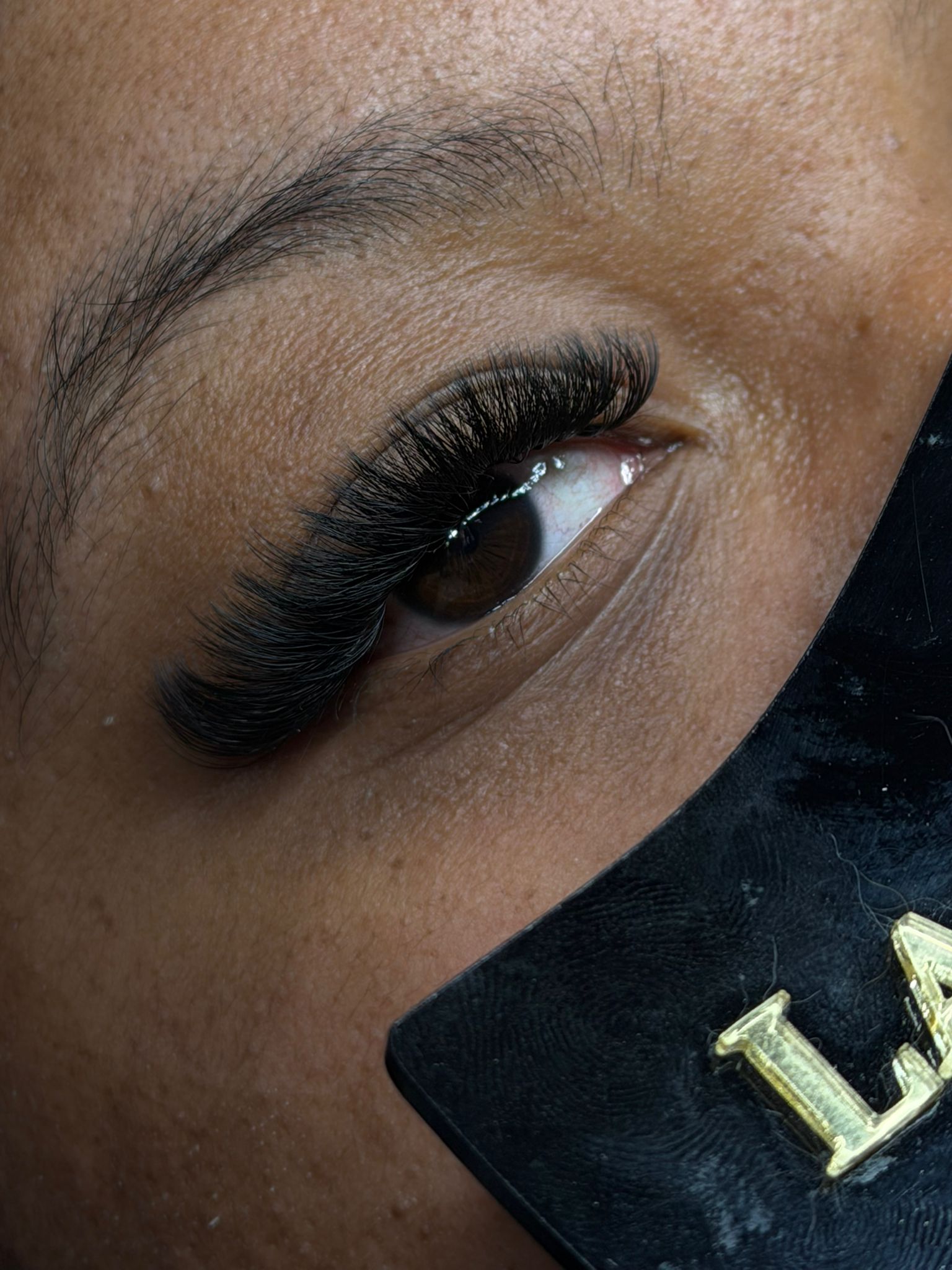 Extension de cils volume russe sur peau foncée – résultat dense et glamour, pose professionnelle pour un regard profond et captivant.