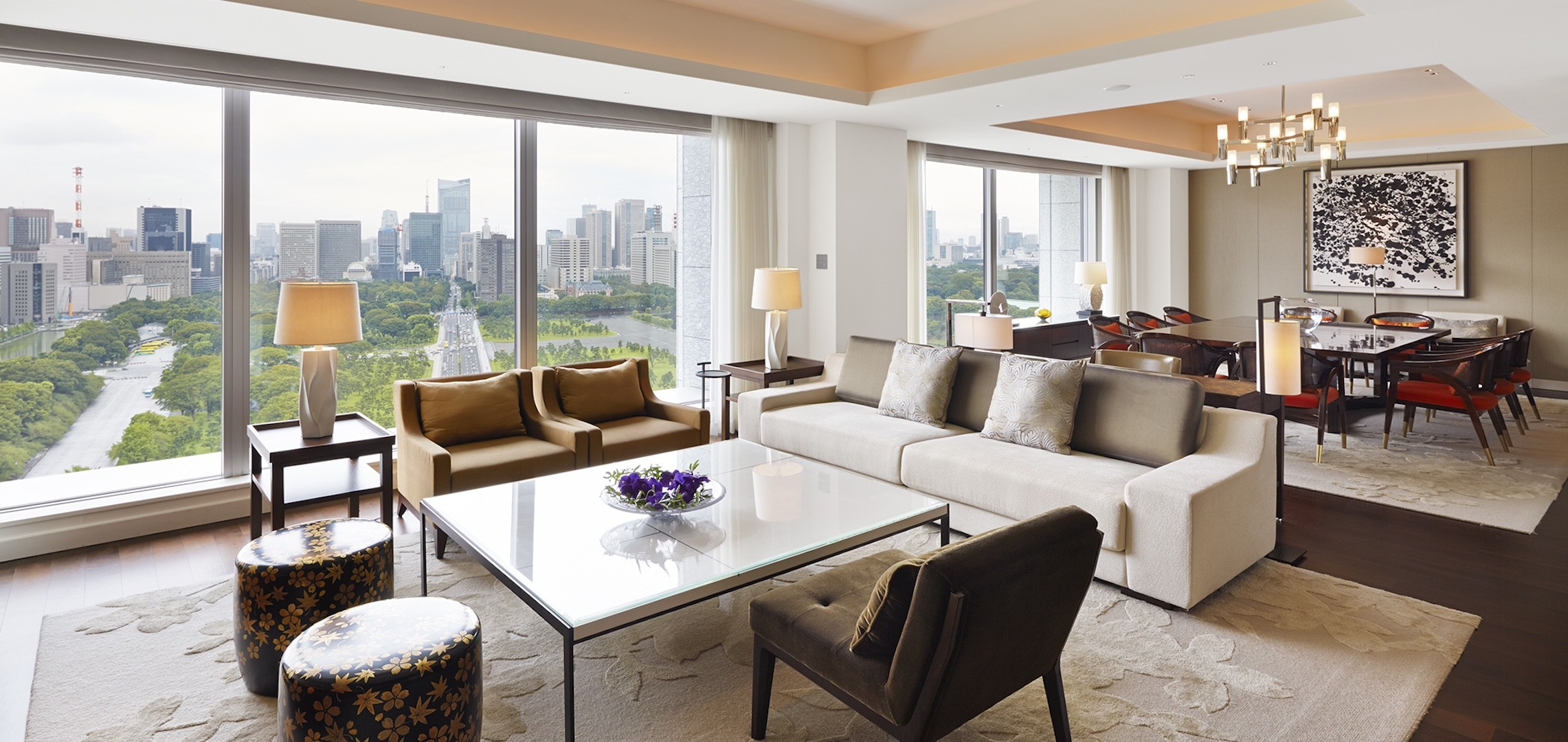 Modernes Wohnzimmer mit Blick auf die Stadt. Sofa, Couchtisch und Blick auf die Skyline durch ein großes Fenster. Luxus Interieur.