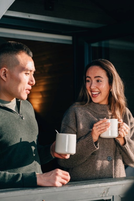 A couple having a hot drink and looking at each other. 