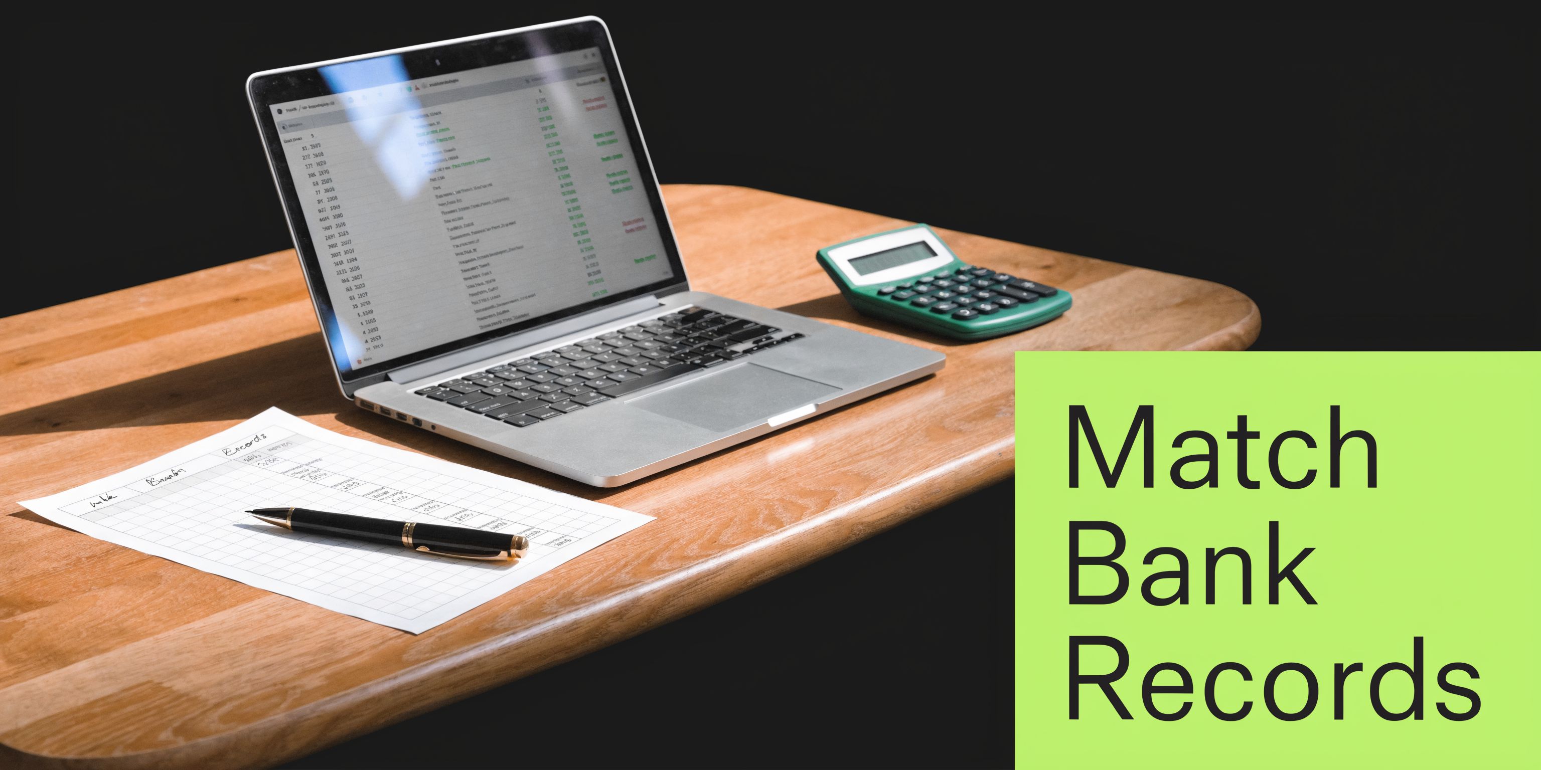 A modern workspace with a laptop displaying financial data, a calculator, and a pen on paper records.