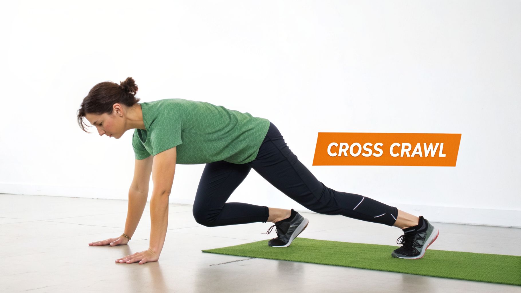 A woman in green and black athletic wear performs a Cross Crawl exercise on a green mat on a light floor.