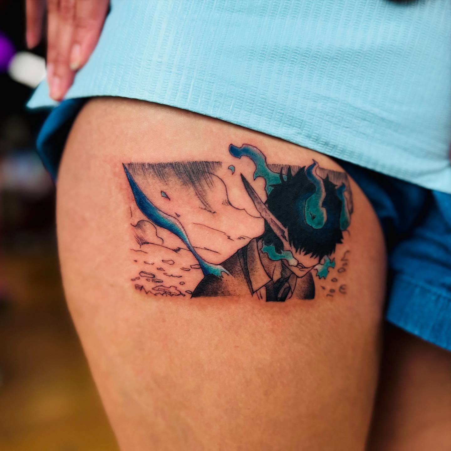 A grayscale anime-style tattoo of a character with spiky hair and a headband, holding a kunai.  The tattoo is on someone's forearm.