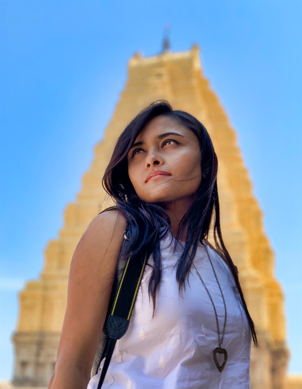 woman in white and red dress standing on green grass field during daytime
