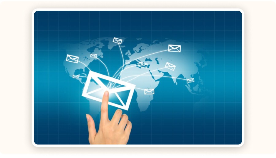 Hand interacting with email icons connected across a world map&nbsp;
