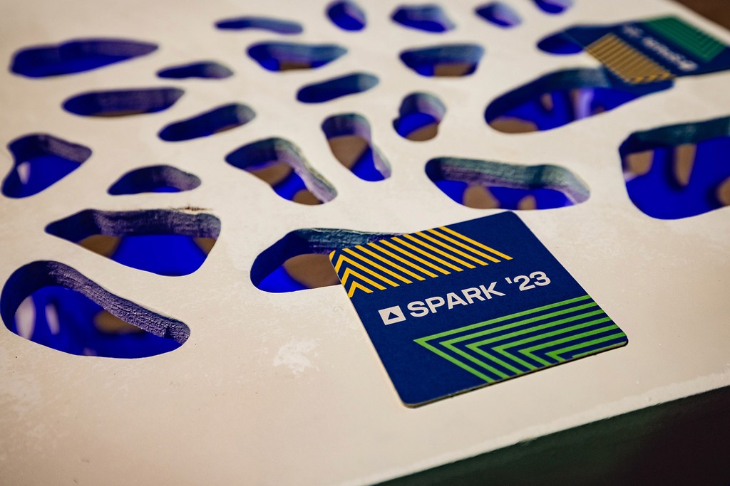 Photo of a SPARk branded coaster on a modern table. 