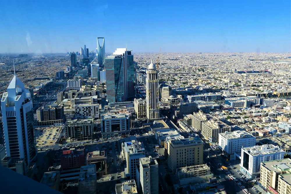 Aerial view of Riyadh, Saudi Arabia, featuring the Kingdom Centre and dense downtown skyline.