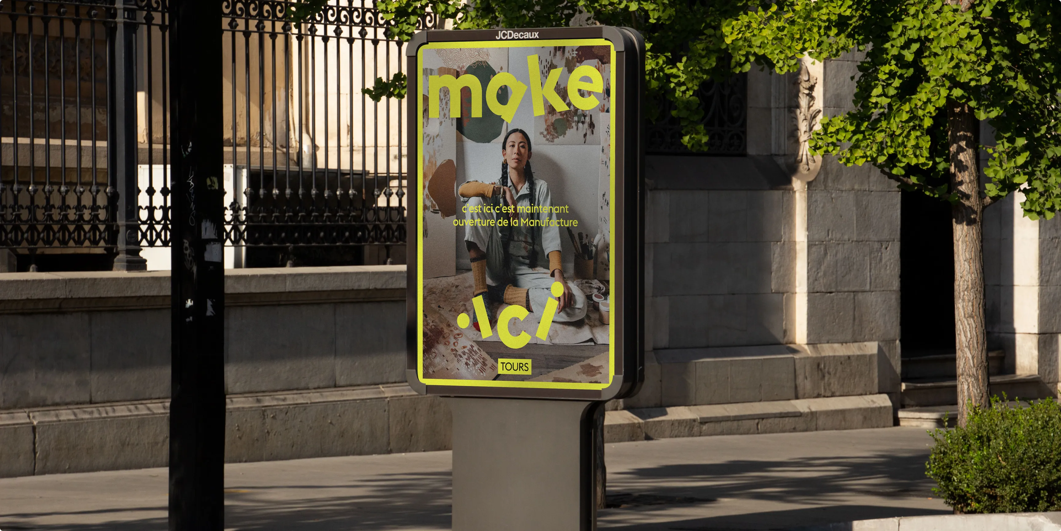 A bus stop shelter with a colorful advertisement poster surrounded by greenery and urban settings.