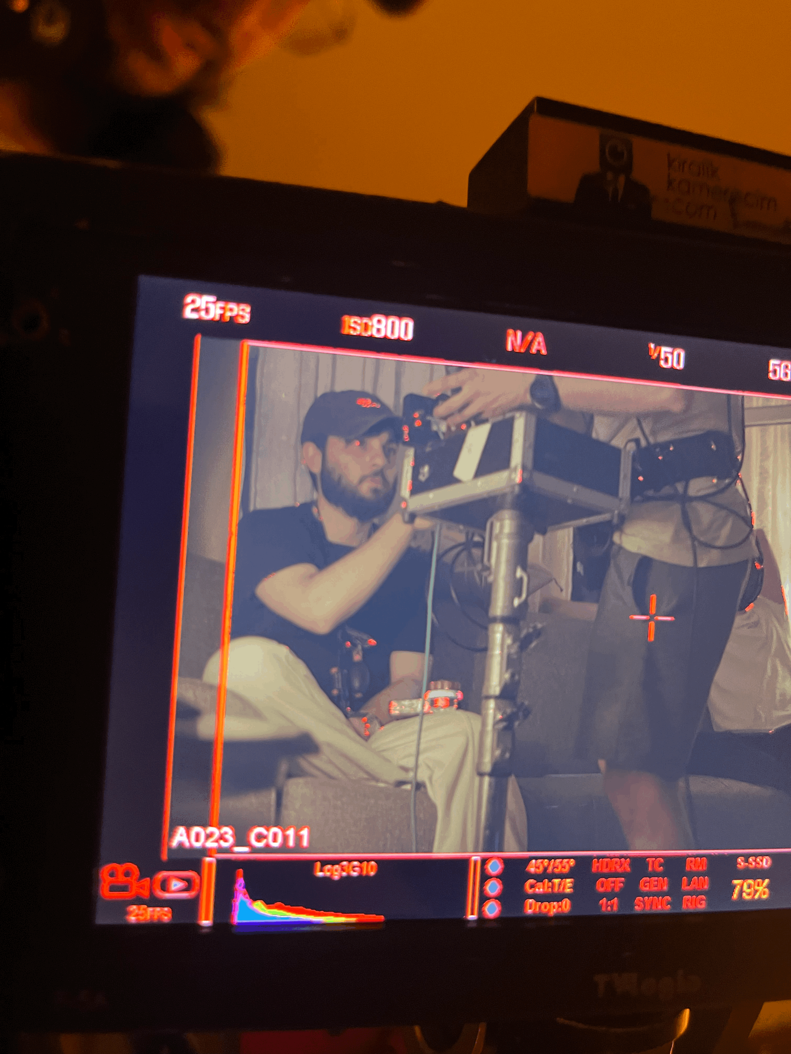 a man standing next to a camera on a tripod