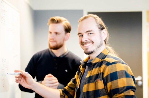 Twee mannen bespreken een grafiek met de titel 'Incidenten per categorie', die de verdeling van incidenten in verschillende kleurencategorieën toont, waaronder transport, schade en communicatie.