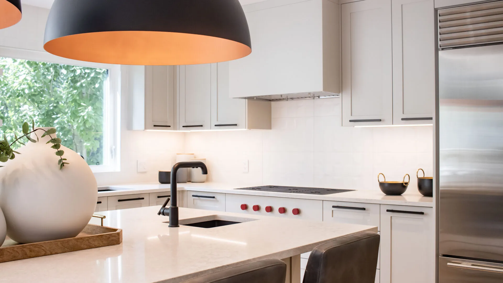 Image of kitchen with light grey millwork and large dome lights.