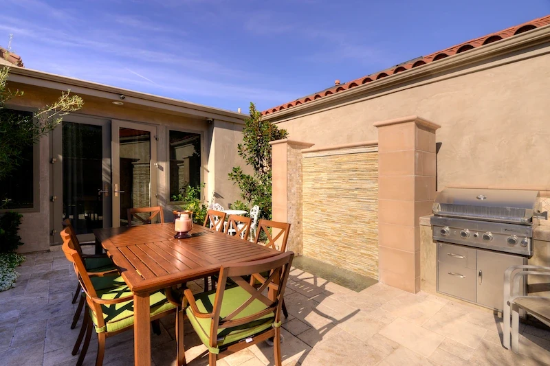 Harbor Ridge Transitional Remodel courtyard with outdoor grill, dining set, and water feature.