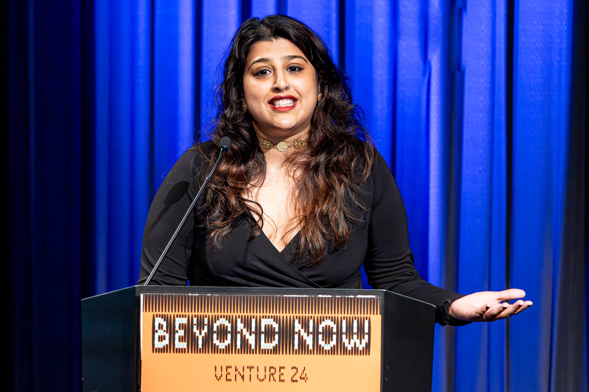 a student at a podium presenting a project in a Theatre