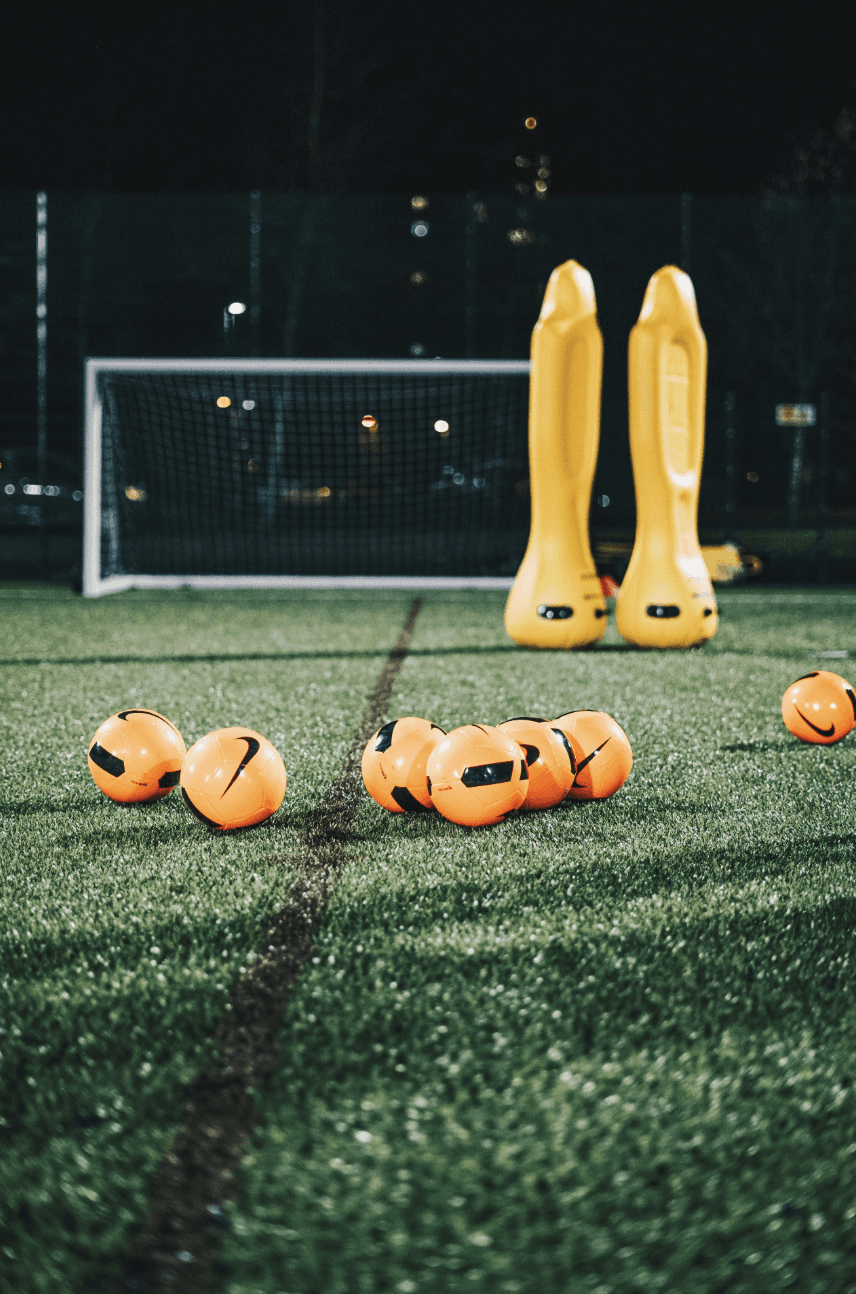 a group of yellow and orange balls on a green field
