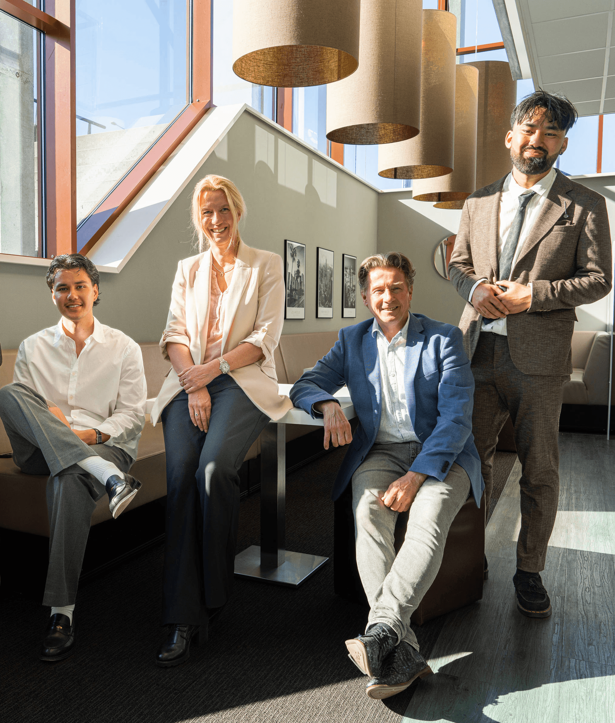 The SETTL team smiling and sitting together in their Amsterdam office