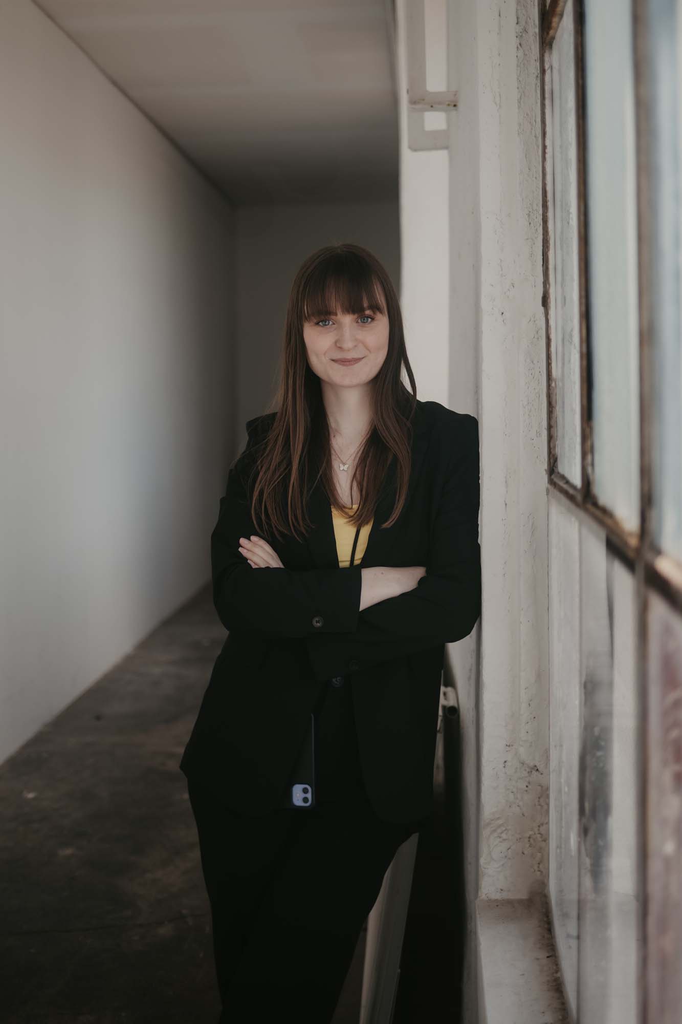 Hochzeitsplanerin Emily schaut lächelnd in die Kamera.