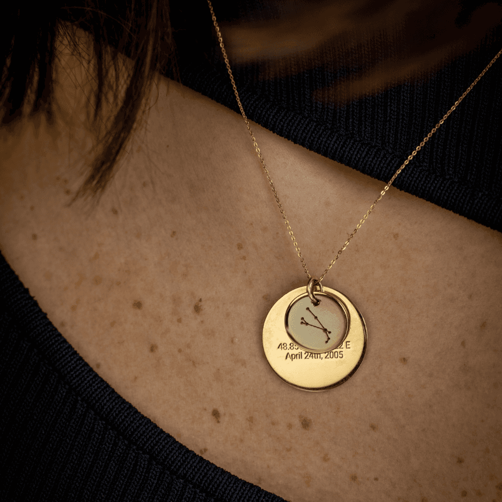 A gold Aries Night Sky Star Sign pendant layered on a gold Night Sky Star Map pendant. 