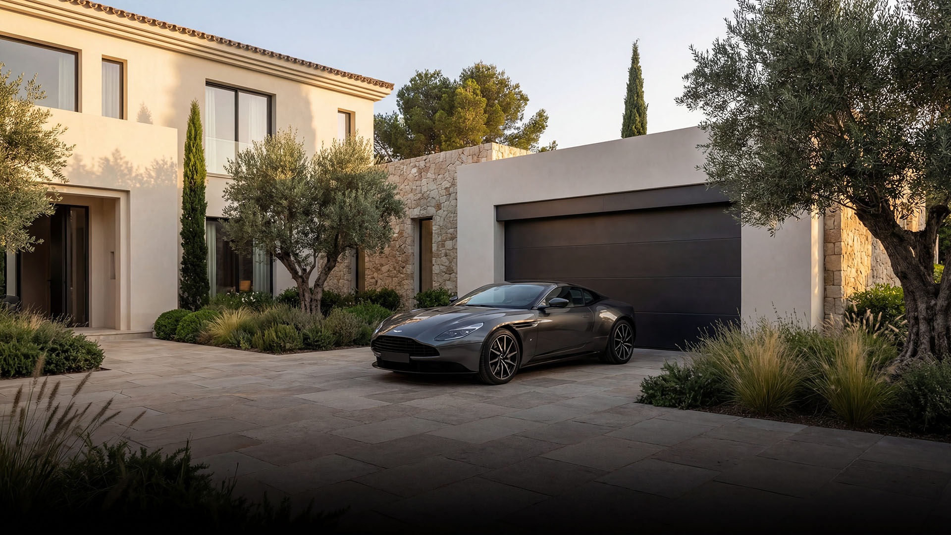 Modern luxury villa entrance in Marbella with natural stone facade, landscaped garden, and sleek sports car parked in the driveway