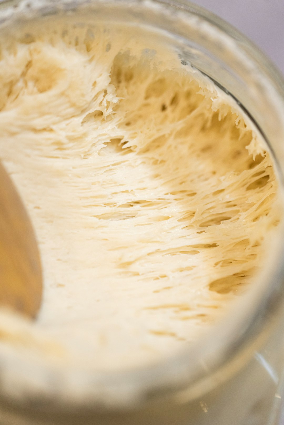 A wooden spoon inside of a jar filled with liquid
