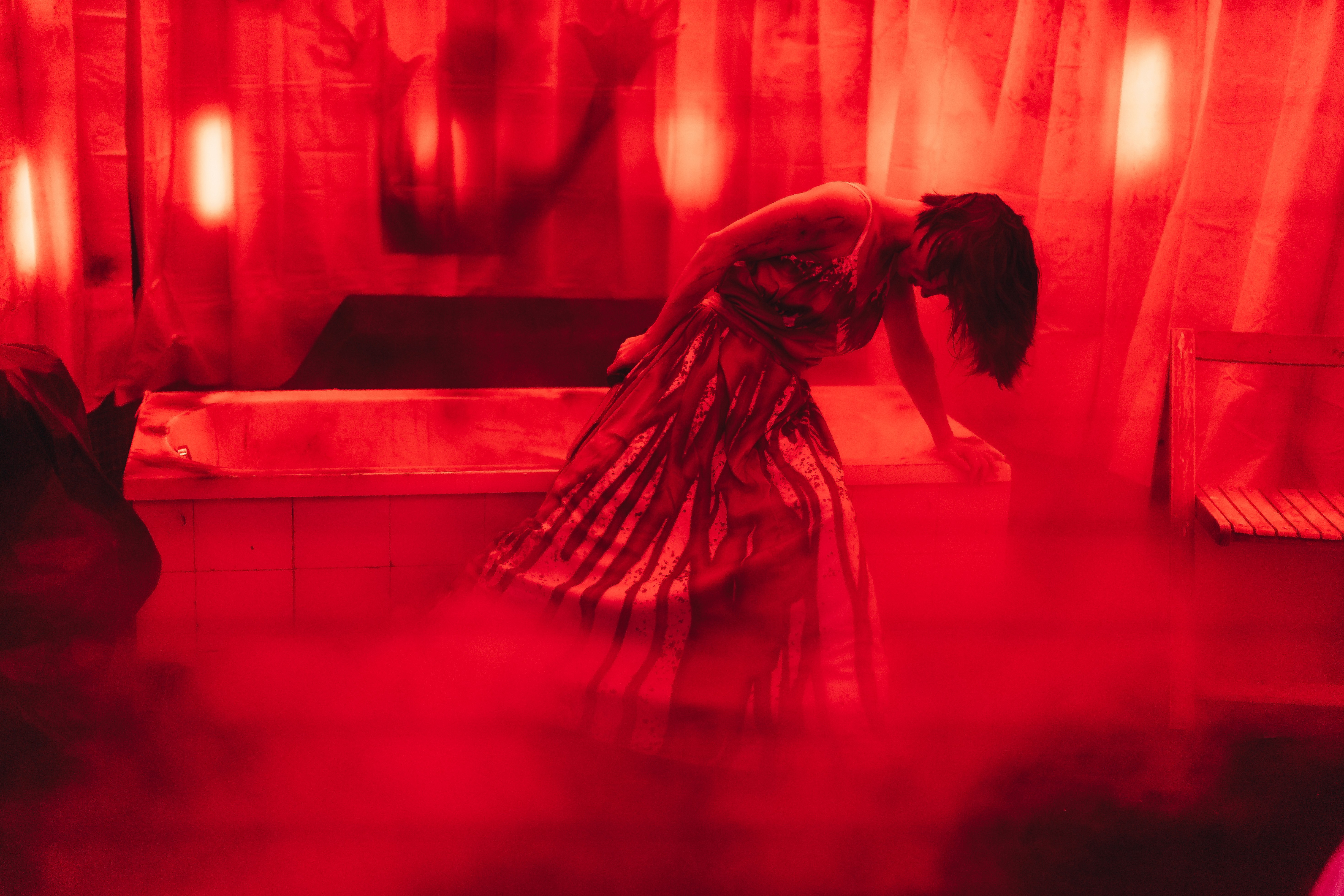 Halloween bathtub horror performer in bloody red costume with fog effects and red lighting at Stage nightclub Dubai