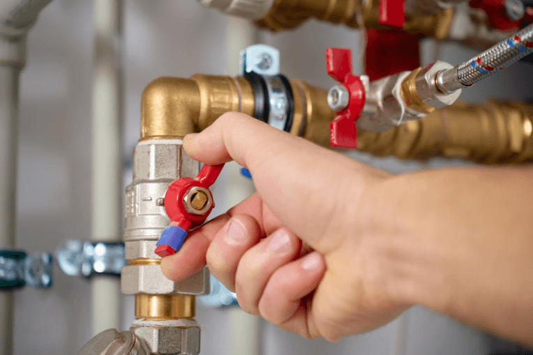 Turning off a plumbing valve as part of preventative maintenance procedure.