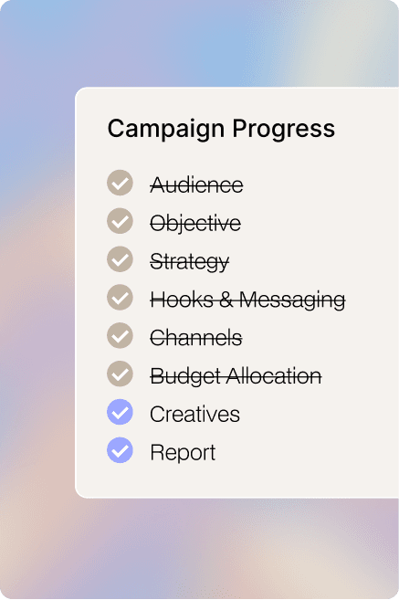 A man in a dark sweater and a woman in glasses wearing a navy blouse sit together at a desk, smiling at the camera with a laptop in front of them.