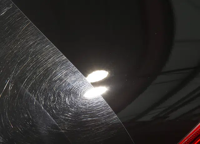Refined black paint surface reflecting detailing lights