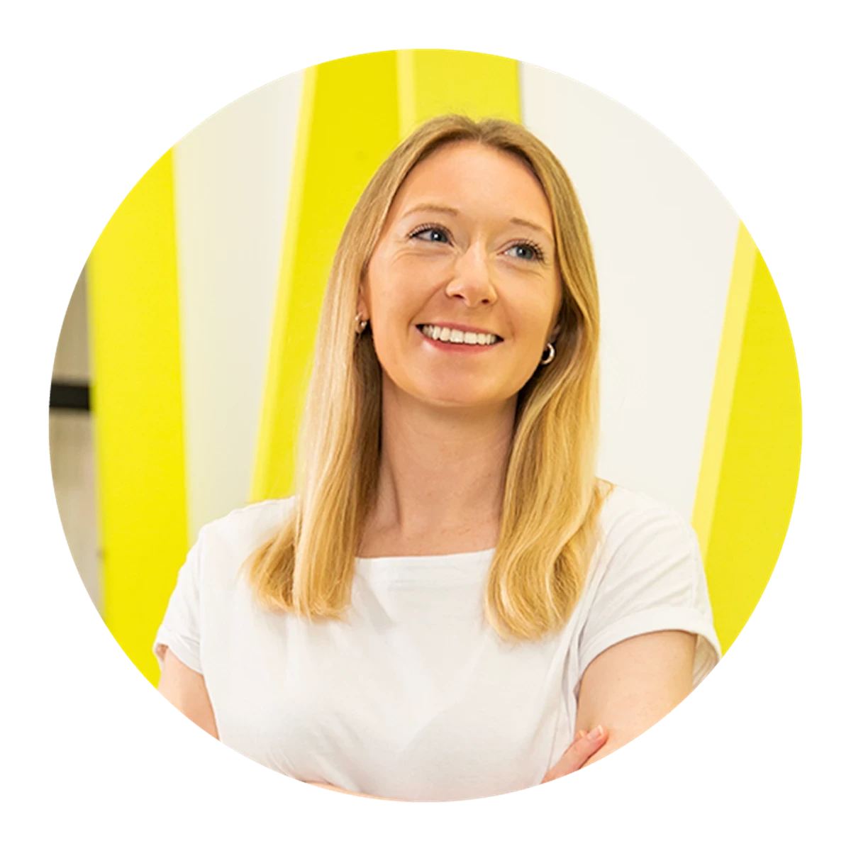 Person with straight blonde hair wearing a white t-shirt in front of a yellow and white background.