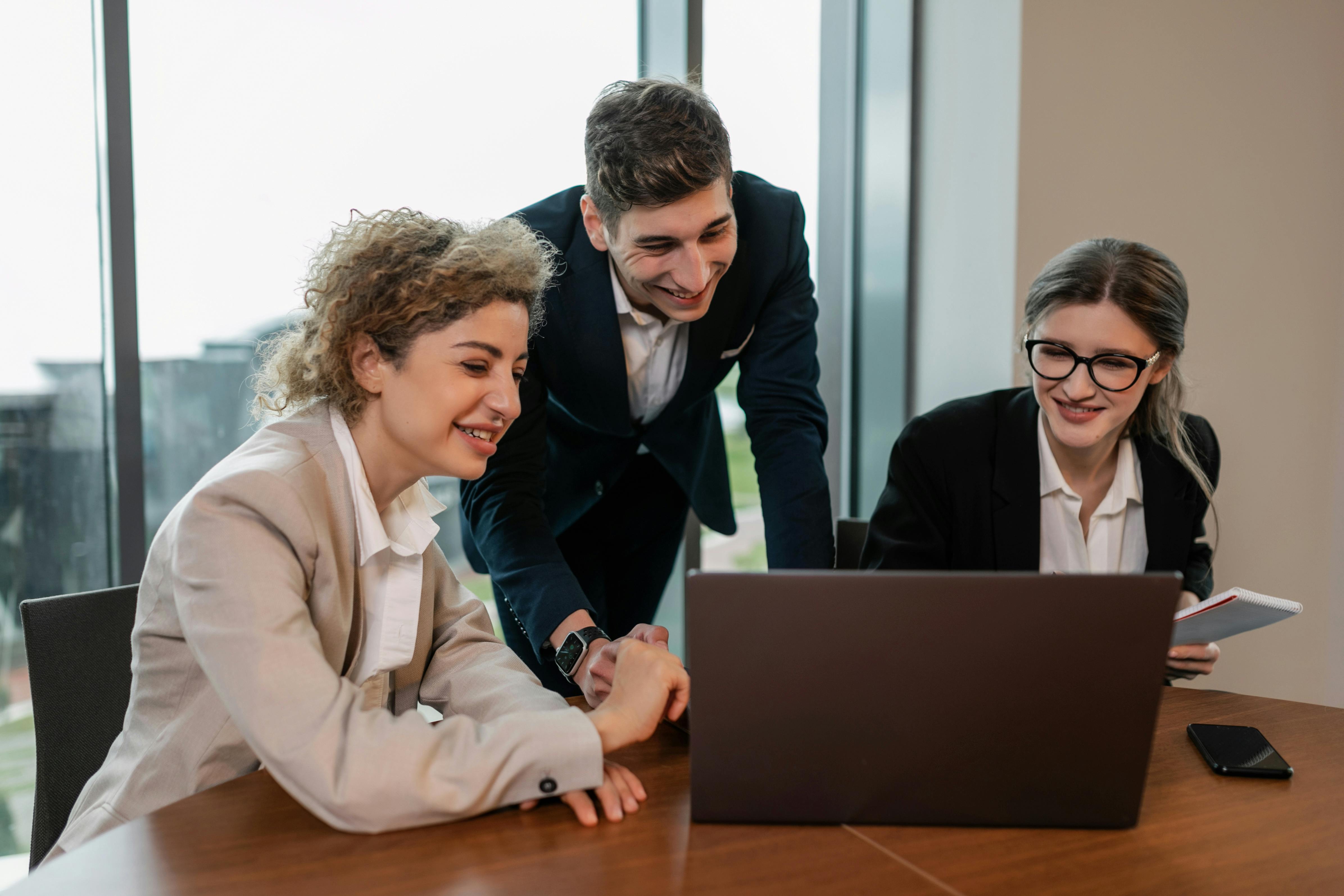 Giovani professionisti che collaborano davanti a un computer, rappresentazione del confronto e del bisogno di orientamento dopo la laurea in un mercato del lavoro competitivo.