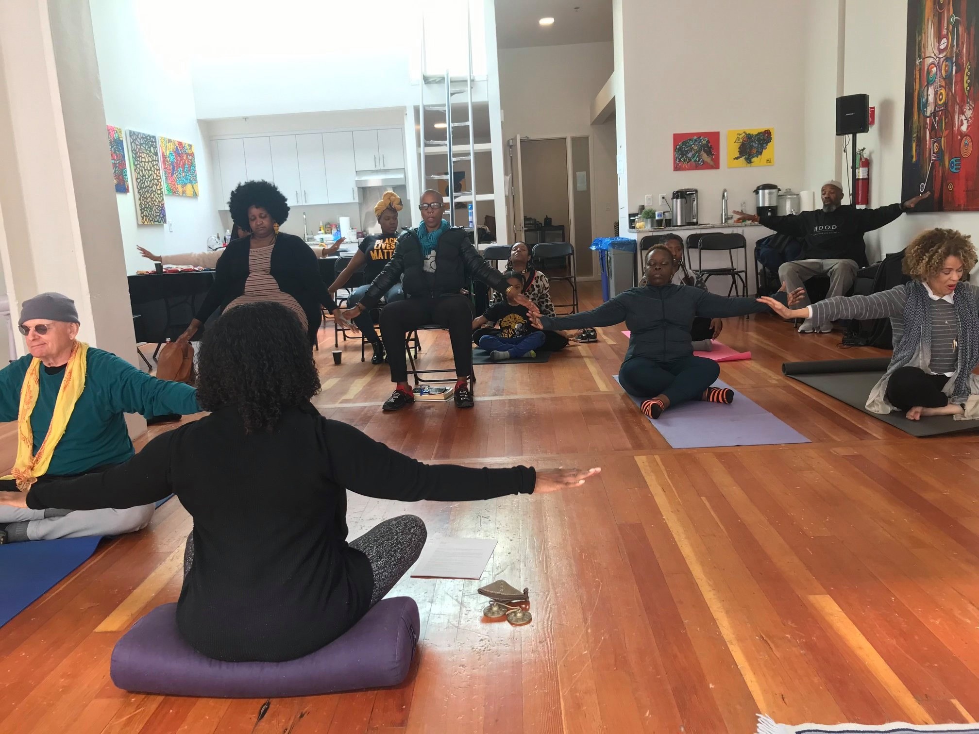 A group of four people engaged in a discussion while seated in a cozy, plant-filled setting.