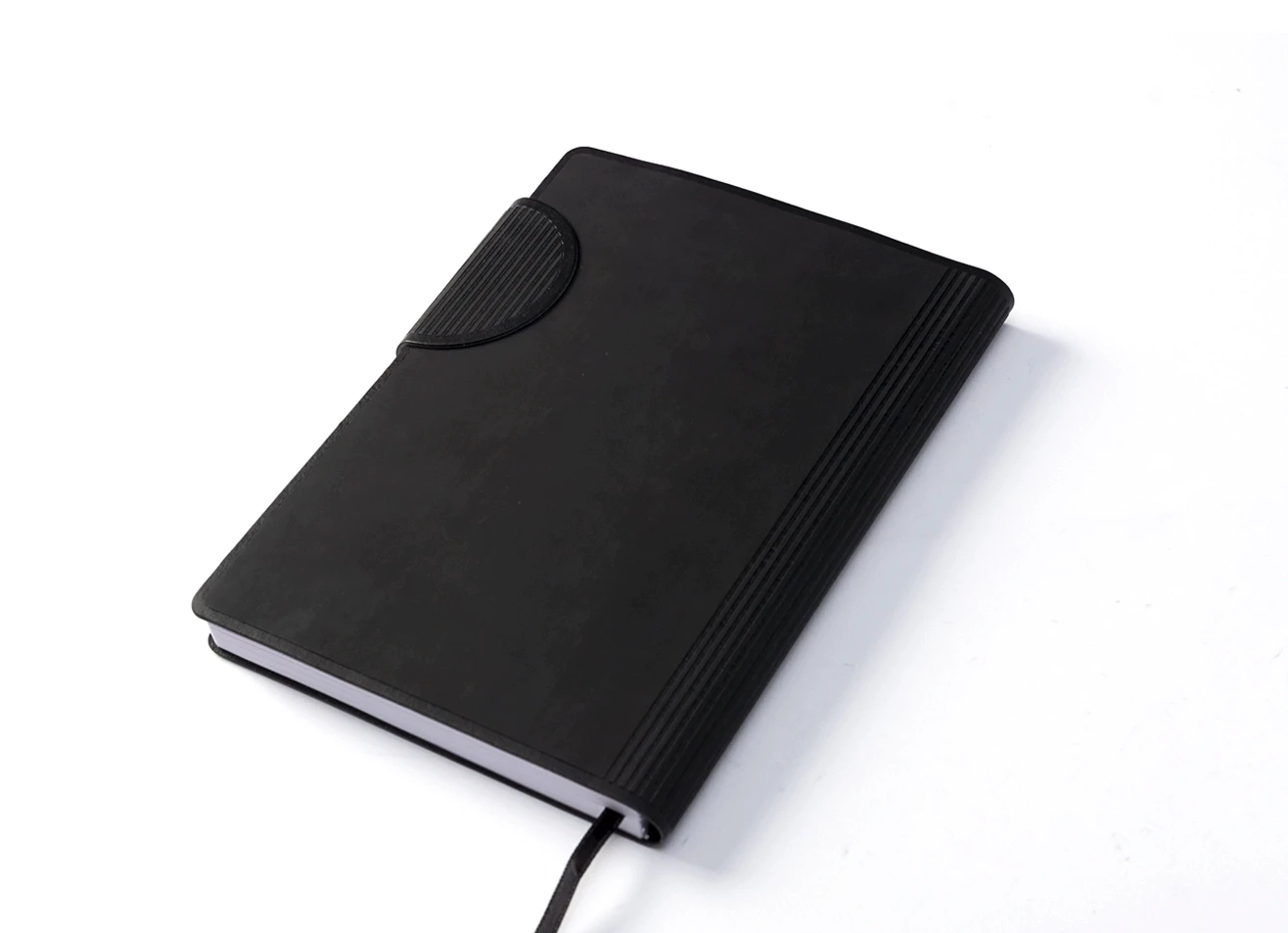 Angled view of black strap closure journal with textured spine detail