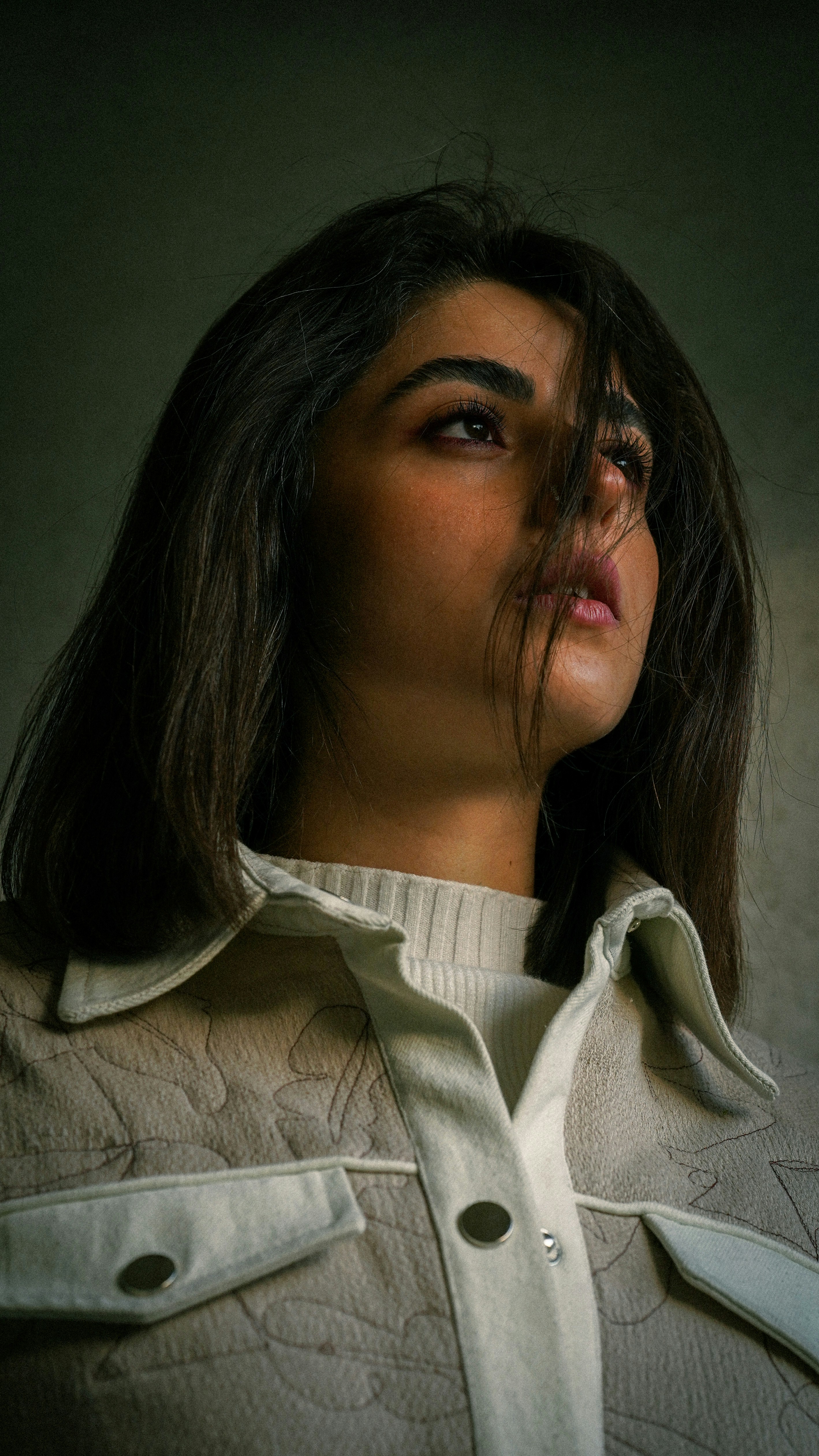 a woman with her eyes closed and her hair blowing in the wind