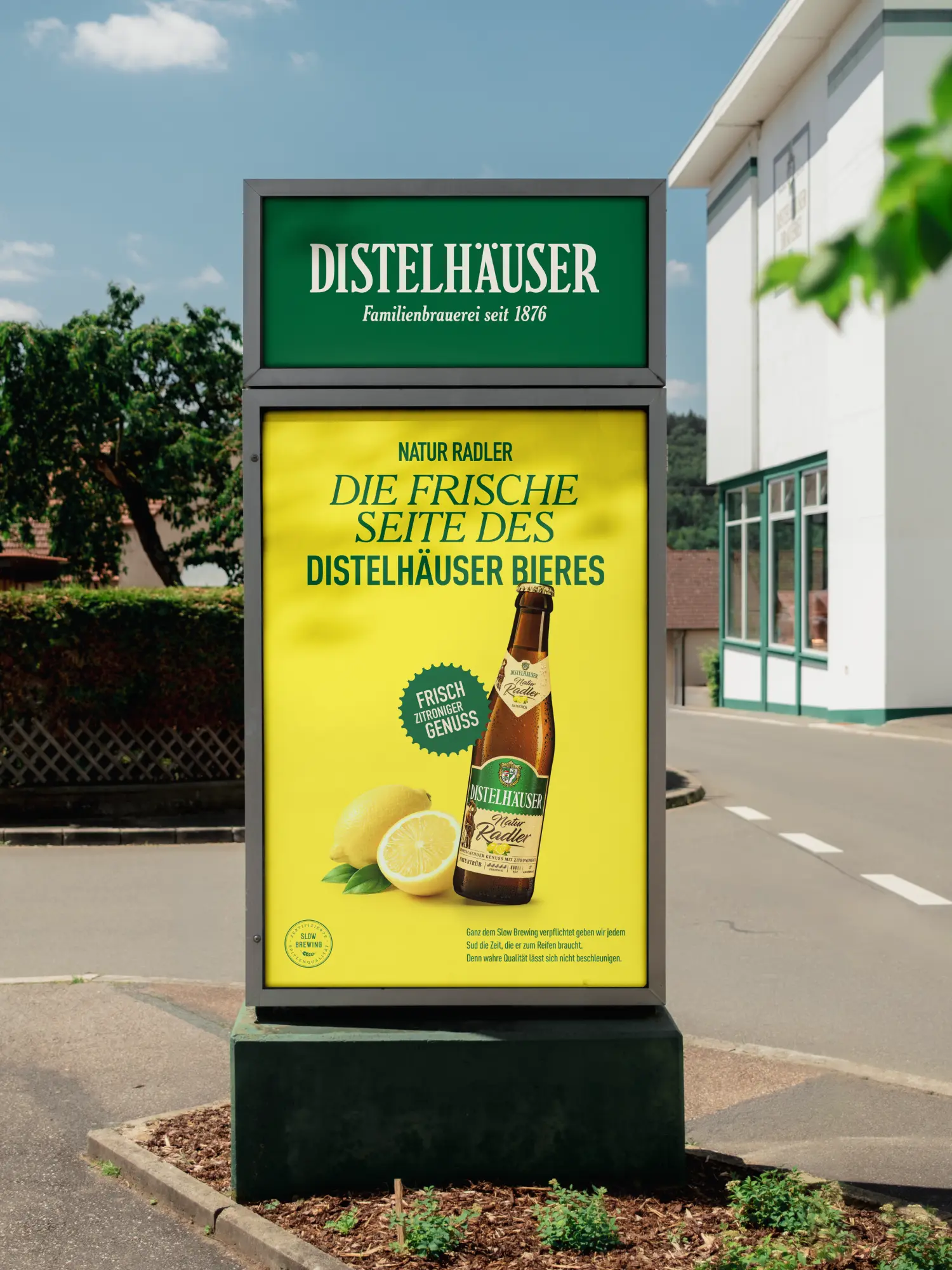 Werbetafel für Distelhäuser Natur Radler mit Flasche und Zitronen auf gelbem Hintergrund