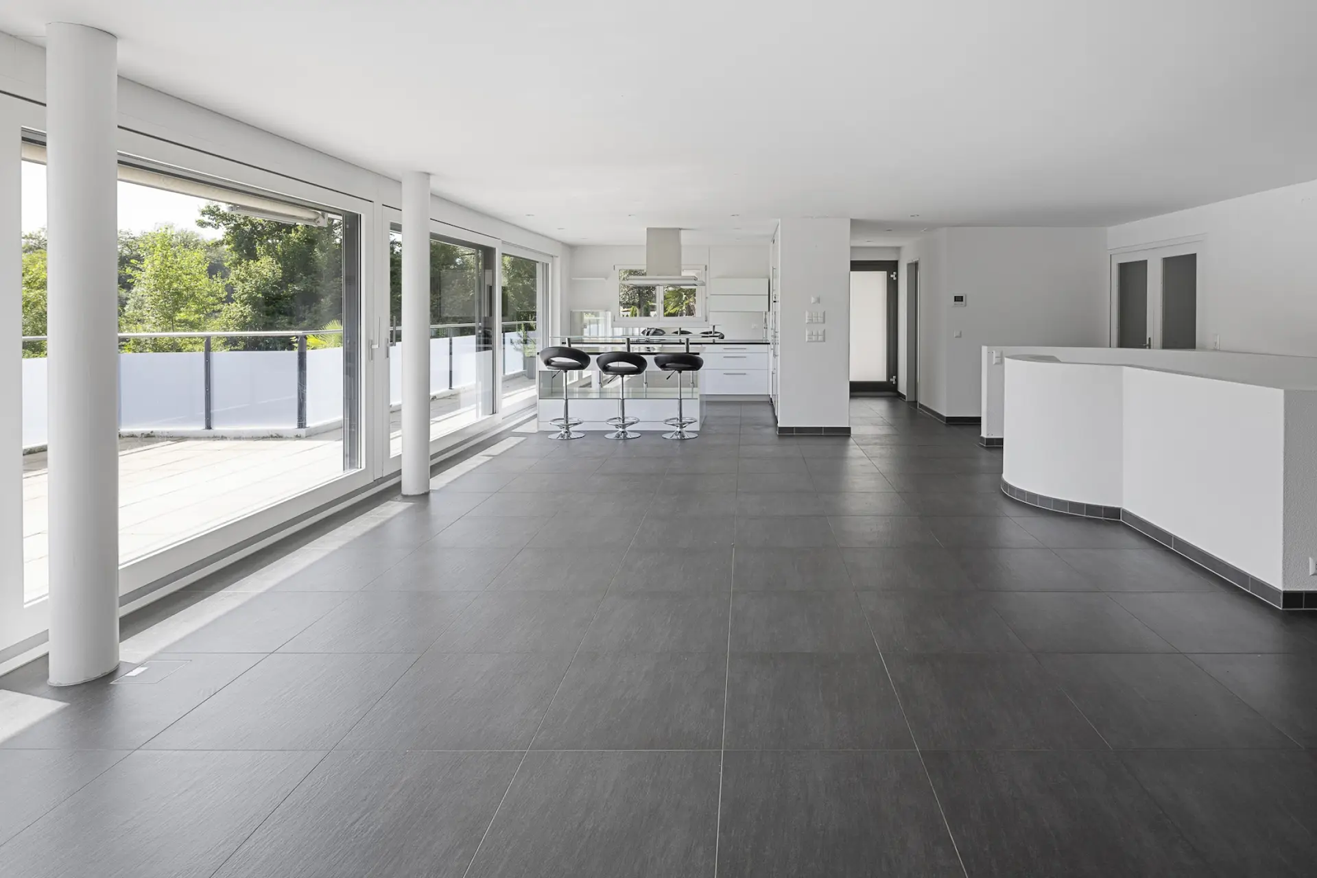Immobilienfoto einer modernen Küche mit Tresen und Barhockern