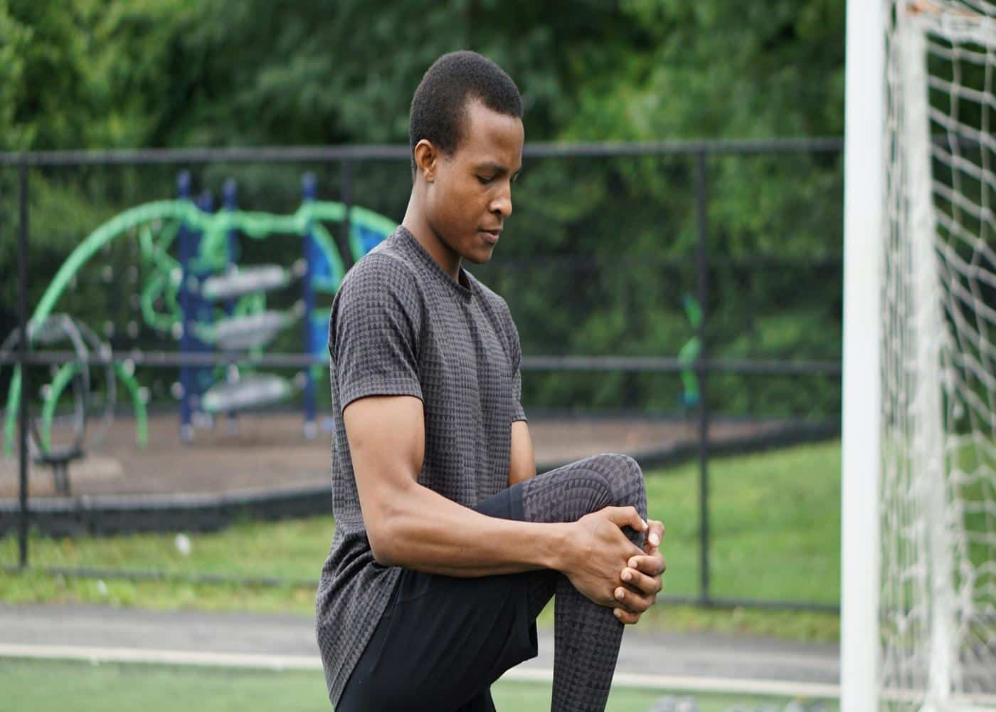 Improving flexibility - Man stretching in front of a soccer goal
