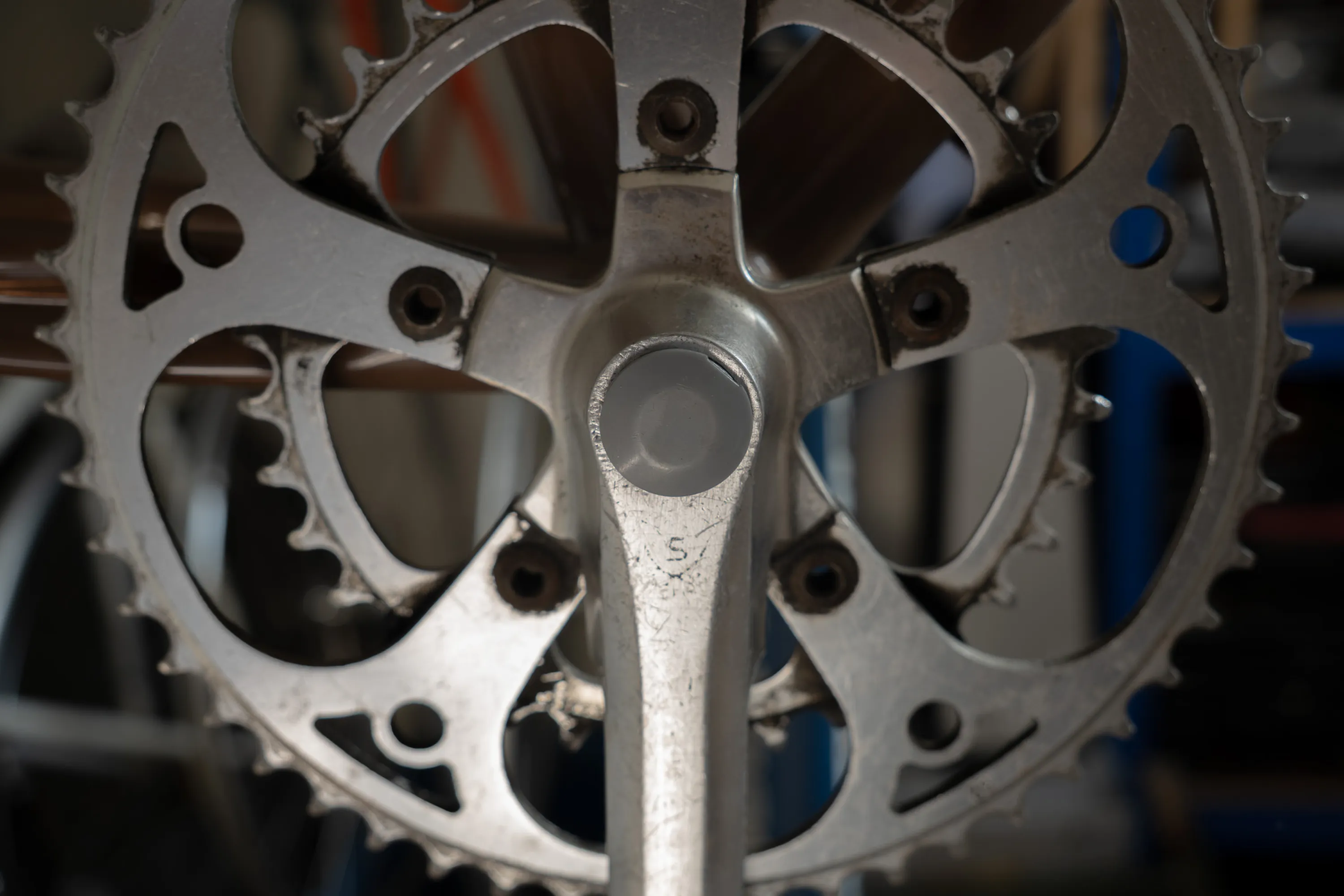 A close up of a person working on a bike crankset