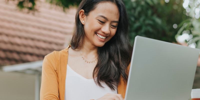 A retail owner uses her laptop to build a website