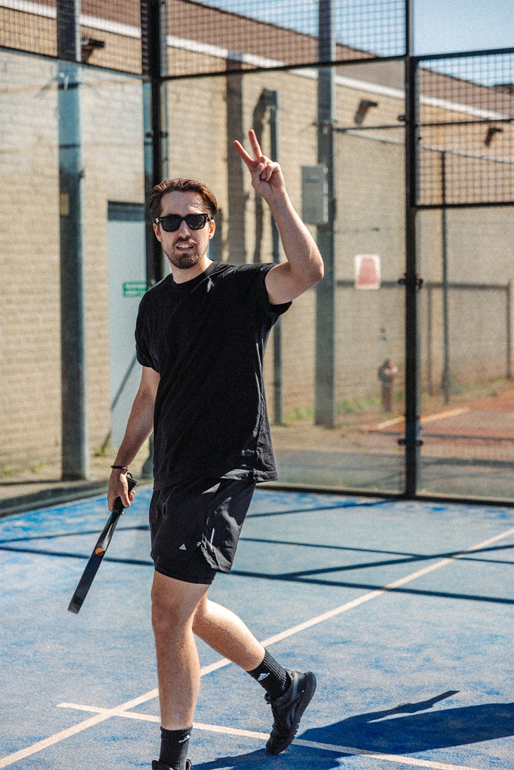 Four people gathered in a bright room, working together at a laptop on a small table.
