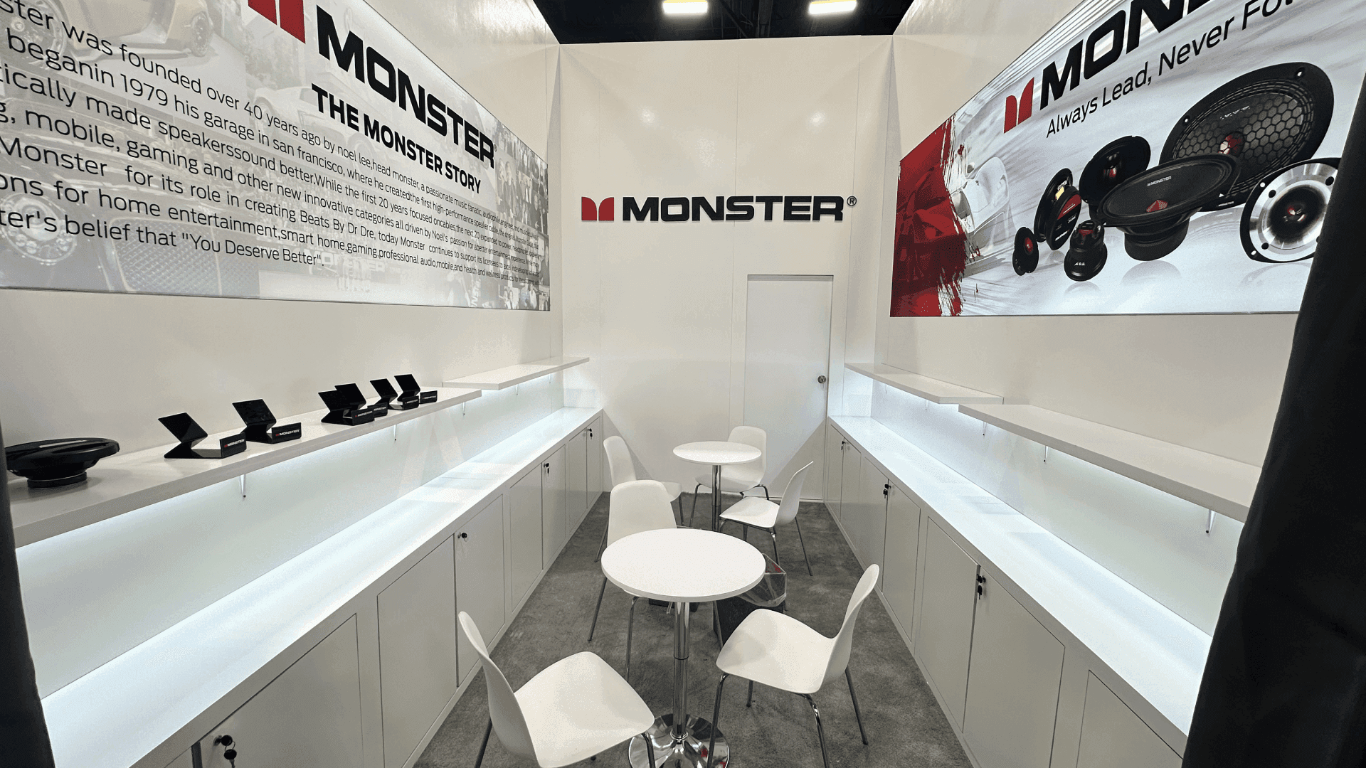 Automotive trade show meeting area with product display shelves, branded graphics, seating space, and buyer conversation layout
