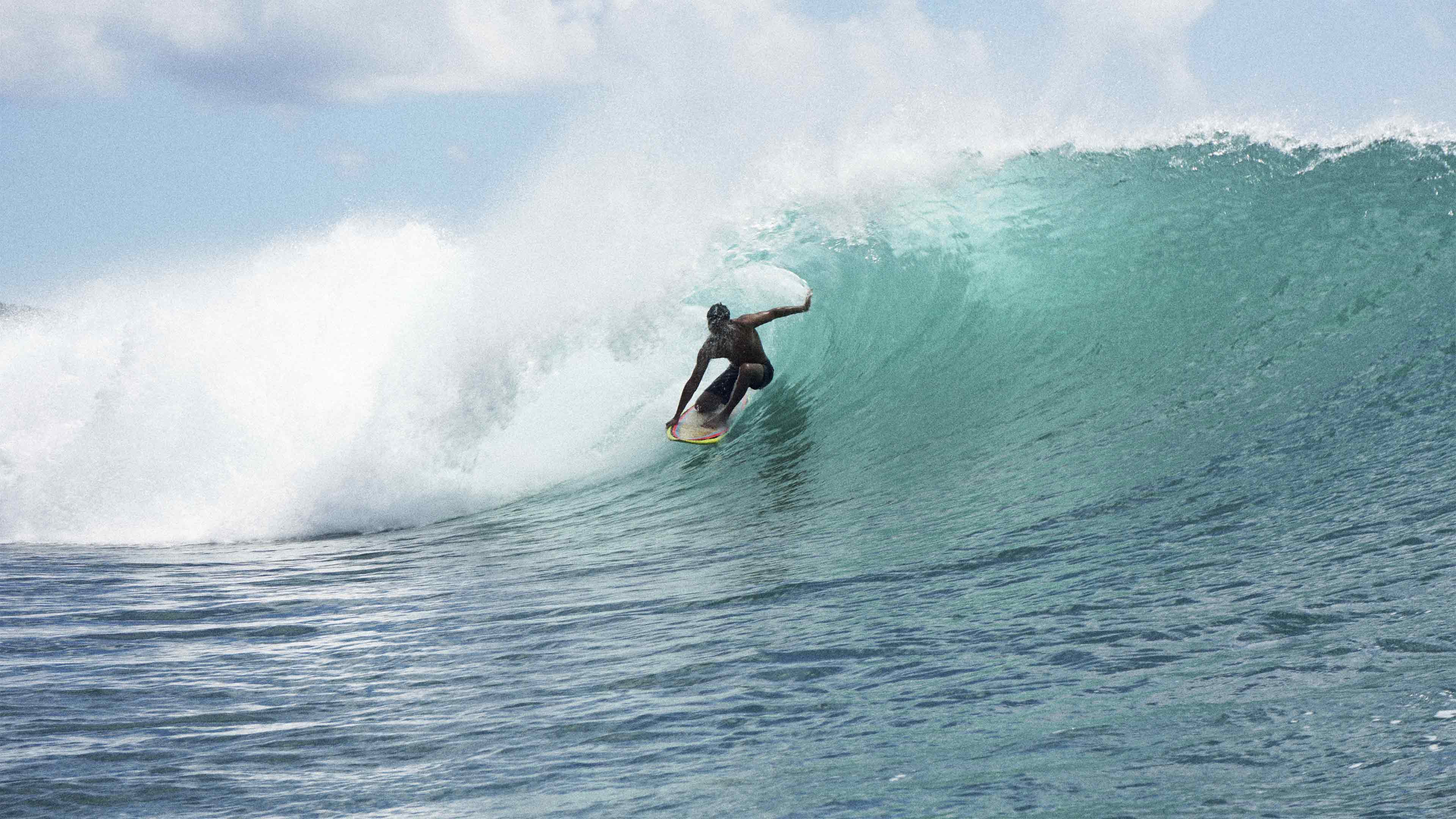 Surfer inside the barrel of a tropical wave