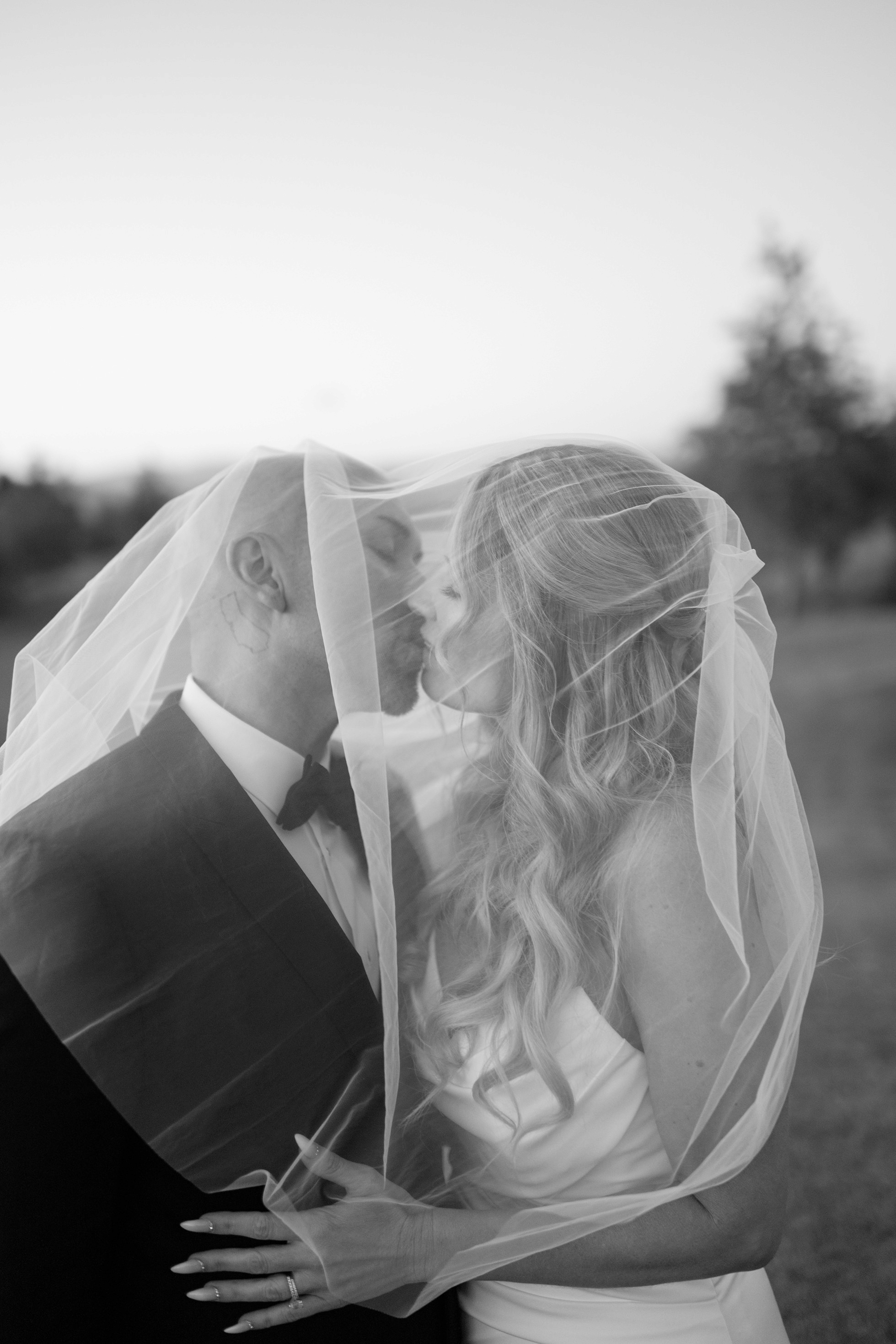 Bride and groom under veil portrait in black and white